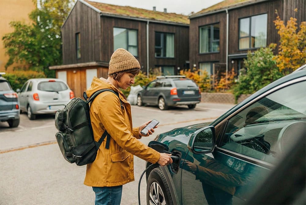 Kvinna kopplar in elbilsladdning