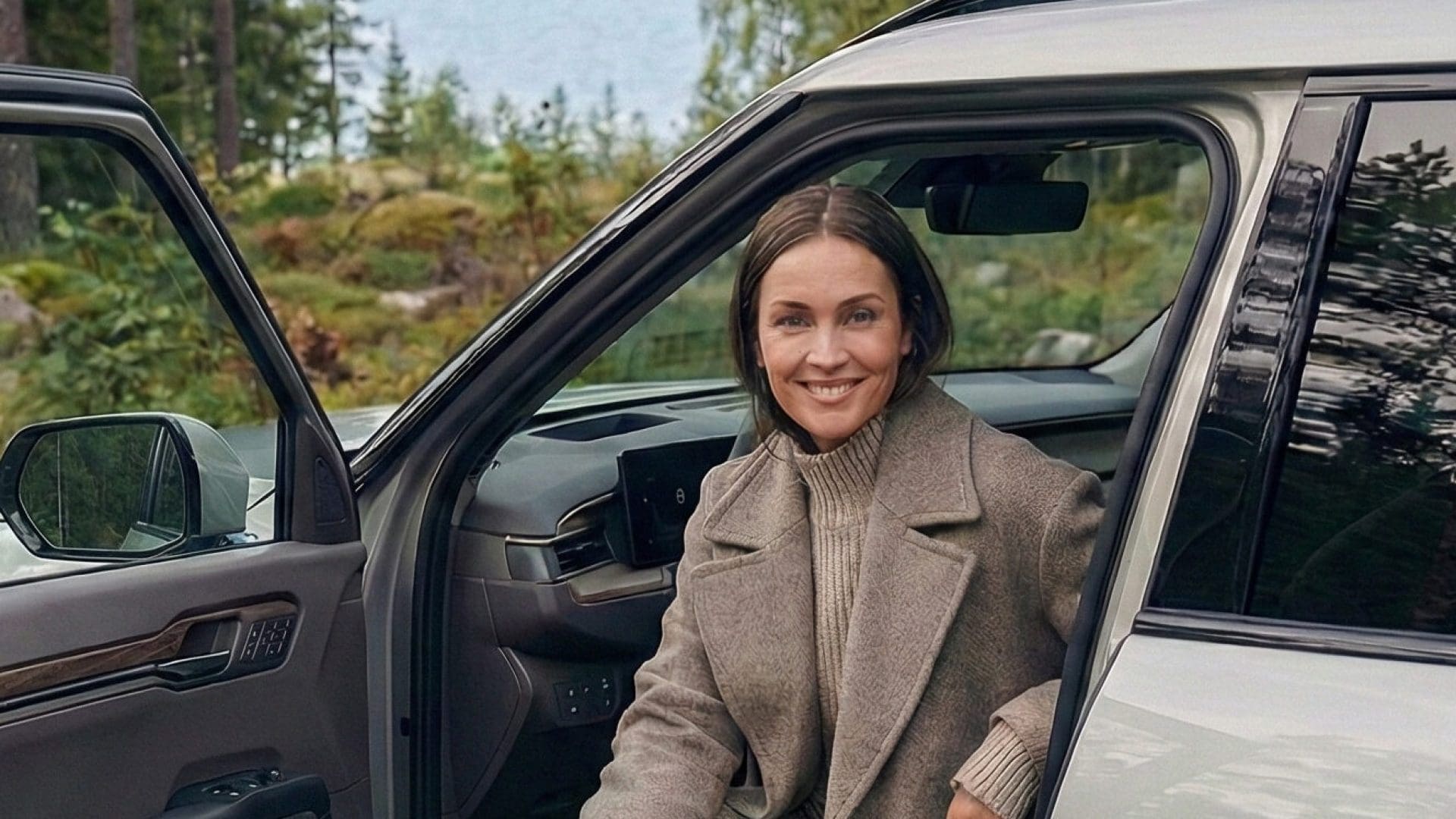 Kvinna i elbil som installerat laddstolpar med laddboxar i en brf